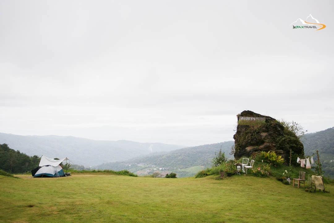 XPAX Travel Phupetra Chiang Mai – a cozy hilltop stay near Mon Jam with panoramic mountain views and peaceful natural surroundings. The highlight is its unique natural rock formation, a beautiful landmark right in front of the resort. Rooms are designed in a cute, minimalist Wabi-Sabi style, complete with full amenities. Guests can stargaze and enjoy mountain views right from their beds. The Farm Suk House offers a charming two-story stay with a lovely living room and a warm upstairs bedroom. There’s also a tent area for campers who love sleeping under the stars. Around the property, you’ll find lush vegetable gardens and colorful flower fields – perfect for photos and walks. In the evening, enjoy Thai BBQ on the balcony net while watching the sunset over the hills. Breakfast is served in-room, beautifully presented, and guests are welcomed with an afternoon tea set upon check-in. Phupetra offers a calm, romantic, storybook-like atmosphere, perfect for couples, families, and friends who want to relax in nature. Book your stay with XPAX Travel this winter to experience happiness, comfort, and breathtaking views all in one place.ที่พักภูเปตรา เชียงใหม่ อยู่บนเนินเขาใกล้ม่อนแจ่ม วิวภูเขาสวยแบบไม่มีอะไรมาบัง เห็นธรรมชาติรอบด้าน จุดเด่นคือหินธรรมชาติหน้าที่พักสวยโดดเด่นไม่เหมือนใคร ห้องพักตกแต่งสไตล์มินิมอลวาบิซาบิ นอนได้ชมวิวและดูดาวจากเตียง ภายในมีสิ่งอำนวยความสะดวกครบครัน มีทั้งบ้านฟาร์มสุขสองชั้นสุดน่ารักพร้อมห้องนั่งเล่นและห้องนอนวิวเขา และโซนกางเต็นท์สำหรับคนนอนชมดาว รอบที่พักมีสวนผักและสวนดอกไม้ให้เดินเล่นถ่ายรูปได้ทั้งวัน ตอนเย็นสามารถนั่งกินหมูกระทะบนระเบียงตาข่ายพร้อมวิวภูเขา อาหารเช้าเสิร์ฟถึงห้องหน้าตาน่าทานมาก พร้อมเซตอาฟเตอร์นูนทีต้อนรับตอนเช็คอิน บรรยากาศอบอุ่น เงียบสงบ ฟีลเหมือนอยู่บ้านในนิยาย เหมาะกับคู่รัก ครอบครัว และเพื่อนที่อยากพักผ่อนท่ามกลางธรรมชาติ หน้าหนาวนี้แนะนำจองที่พักภูเปตรากับ XPAX Travel เพื่อสัมผัสวิวสวย ความสุข และความสบายครบในที่เดียว