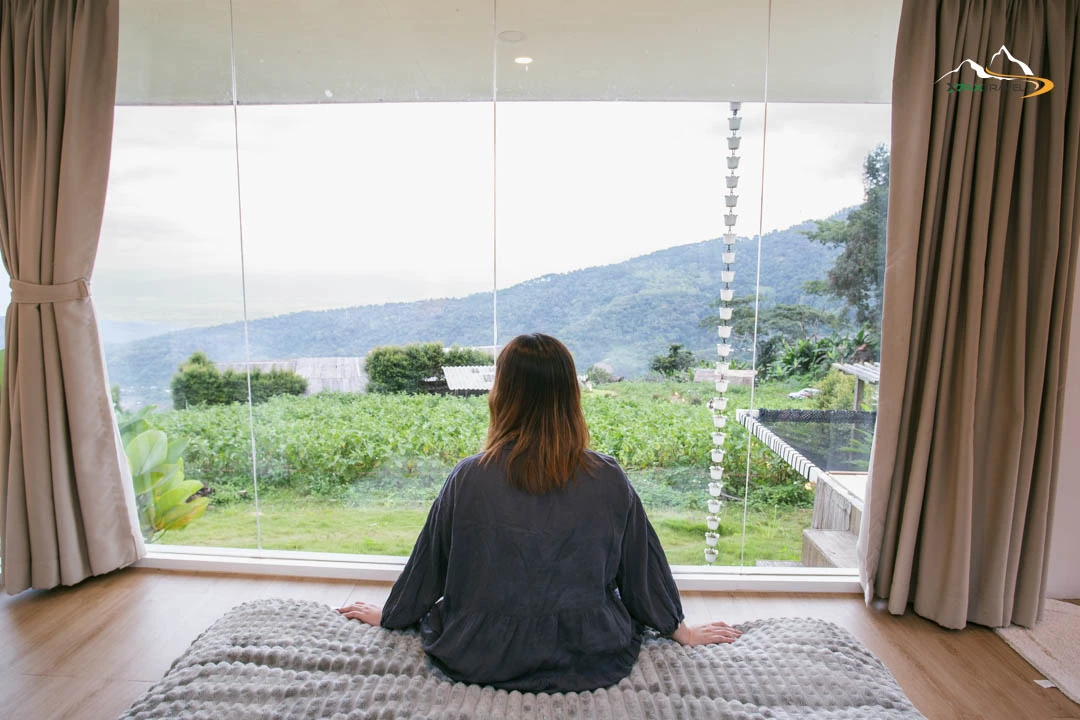 XPAX Travel Phupetra Chiang Mai – a cozy hilltop stay near Mon Jam with panoramic mountain views and peaceful natural surroundings. The highlight is its unique natural rock formation, a beautiful landmark right in front of the resort. Rooms are designed in a cute, minimalist Wabi-Sabi style, complete with full amenities. Guests can stargaze and enjoy mountain views right from their beds. The Farm Suk House offers a charming two-story stay with a lovely living room and a warm upstairs bedroom. There’s also a tent area for campers who love sleeping under the stars. Around the property, you’ll find lush vegetable gardens and colorful flower fields – perfect for photos and walks. In the evening, enjoy Thai BBQ on the balcony net while watching the sunset over the hills. Breakfast is served in-room, beautifully presented, and guests are welcomed with an afternoon tea set upon check-in. Phupetra offers a calm, romantic, storybook-like atmosphere, perfect for couples, families, and friends who want to relax in nature. Book your stay with XPAX Travel this winter to experience happiness, comfort, and breathtaking views all in one place.ที่พักภูเปตรา เชียงใหม่ อยู่บนเนินเขาใกล้ม่อนแจ่ม วิวภูเขาสวยแบบไม่มีอะไรมาบัง เห็นธรรมชาติรอบด้าน จุดเด่นคือหินธรรมชาติหน้าที่พักสวยโดดเด่นไม่เหมือนใคร ห้องพักตกแต่งสไตล์มินิมอลวาบิซาบิ นอนได้ชมวิวและดูดาวจากเตียง ภายในมีสิ่งอำนวยความสะดวกครบครัน มีทั้งบ้านฟาร์มสุขสองชั้นสุดน่ารักพร้อมห้องนั่งเล่นและห้องนอนวิวเขา และโซนกางเต็นท์สำหรับคนนอนชมดาว รอบที่พักมีสวนผักและสวนดอกไม้ให้เดินเล่นถ่ายรูปได้ทั้งวัน ตอนเย็นสามารถนั่งกินหมูกระทะบนระเบียงตาข่ายพร้อมวิวภูเขา อาหารเช้าเสิร์ฟถึงห้องหน้าตาน่าทานมาก พร้อมเซตอาฟเตอร์นูนทีต้อนรับตอนเช็คอิน บรรยากาศอบอุ่น เงียบสงบ ฟีลเหมือนอยู่บ้านในนิยาย เหมาะกับคู่รัก ครอบครัว และเพื่อนที่อยากพักผ่อนท่ามกลางธรรมชาติ หน้าหนาวนี้แนะนำจองที่พักภูเปตรากับ XPAX Travel เพื่อสัมผัสวิวสวย ความสุข และความสบายครบในที่เดียว