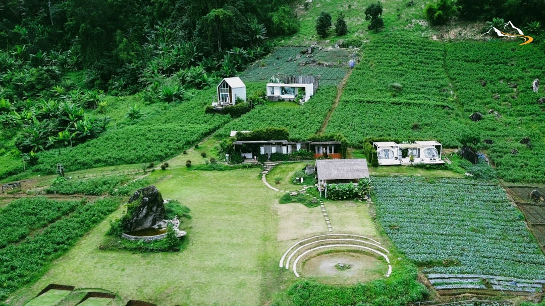 XPAX Travel Phupetra Chiang Mai – a cozy hilltop stay near Mon Jam with panoramic mountain views and peaceful natural surroundings. The highlight is its unique natural rock formation, a beautiful landmark right in front of the resort. Rooms are designed in a cute, minimalist Wabi-Sabi style, complete with full amenities. Guests can stargaze and enjoy mountain views right from their beds. The Farm Suk House offers a charming two-story stay with a lovely living room and a warm upstairs bedroom. There’s also a tent area for campers who love sleeping under the stars. Around the property, you’ll find lush vegetable gardens and colorful flower fields – perfect for photos and walks. In the evening, enjoy Thai BBQ on the balcony net while watching the sunset over the hills. Breakfast is served in-room, beautifully presented, and guests are welcomed with an afternoon tea set upon check-in. Phupetra offers a calm, romantic, storybook-like atmosphere, perfect for couples, families, and friends who want to relax in nature. Book your stay with XPAX Travel this winter to experience happiness, comfort, and breathtaking views all in one place.ที่พักภูเปตรา เชียงใหม่ อยู่บนเนินเขาใกล้ม่อนแจ่ม วิวภูเขาสวยแบบไม่มีอะไรมาบัง เห็นธรรมชาติรอบด้าน จุดเด่นคือหินธรรมชาติหน้าที่พักสวยโดดเด่นไม่เหมือนใคร ห้องพักตกแต่งสไตล์มินิมอลวาบิซาบิ นอนได้ชมวิวและดูดาวจากเตียง ภายในมีสิ่งอำนวยความสะดวกครบครัน มีทั้งบ้านฟาร์มสุขสองชั้นสุดน่ารักพร้อมห้องนั่งเล่นและห้องนอนวิวเขา และโซนกางเต็นท์สำหรับคนนอนชมดาว รอบที่พักมีสวนผักและสวนดอกไม้ให้เดินเล่นถ่ายรูปได้ทั้งวัน ตอนเย็นสามารถนั่งกินหมูกระทะบนระเบียงตาข่ายพร้อมวิวภูเขา อาหารเช้าเสิร์ฟถึงห้องหน้าตาน่าทานมาก พร้อมเซตอาฟเตอร์นูนทีต้อนรับตอนเช็คอิน บรรยากาศอบอุ่น เงียบสงบ ฟีลเหมือนอยู่บ้านในนิยาย เหมาะกับคู่รัก ครอบครัว และเพื่อนที่อยากพักผ่อนท่ามกลางธรรมชาติ หน้าหนาวนี้แนะนำจองที่พักภูเปตรากับ XPAX Travel เพื่อสัมผัสวิวสวย ความสุข และความสบายครบในที่เดียว