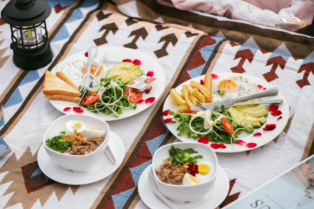 XPAX Travel Phupetra Chiang Mai – a cozy hilltop stay near Mon Jam with panoramic mountain views and peaceful natural surroundings. The highlight is its unique natural rock formation, a beautiful landmark right in front of the resort. Rooms are designed in a cute, minimalist Wabi-Sabi style, complete with full amenities. Guests can stargaze and enjoy mountain views right from their beds. The Farm Suk House offers a charming two-story stay with a lovely living room and a warm upstairs bedroom. There’s also a tent area for campers who love sleeping under the stars. Around the property, you’ll find lush vegetable gardens and colorful flower fields – perfect for photos and walks. In the evening, enjoy Thai BBQ on the balcony net while watching the sunset over the hills. Breakfast is served in-room, beautifully presented, and guests are welcomed with an afternoon tea set upon check-in. Phupetra offers a calm, romantic, storybook-like atmosphere, perfect for couples, families, and friends who want to relax in nature. Book your stay with XPAX Travel this winter to experience happiness, comfort, and breathtaking views all in one place.ที่พักภูเปตรา เชียงใหม่ อยู่บนเนินเขาใกล้ม่อนแจ่ม วิวภูเขาสวยแบบไม่มีอะไรมาบัง เห็นธรรมชาติรอบด้าน จุดเด่นคือหินธรรมชาติหน้าที่พักสวยโดดเด่นไม่เหมือนใคร ห้องพักตกแต่งสไตล์มินิมอลวาบิซาบิ นอนได้ชมวิวและดูดาวจากเตียง ภายในมีสิ่งอำนวยความสะดวกครบครัน มีทั้งบ้านฟาร์มสุขสองชั้นสุดน่ารักพร้อมห้องนั่งเล่นและห้องนอนวิวเขา และโซนกางเต็นท์สำหรับคนนอนชมดาว รอบที่พักมีสวนผักและสวนดอกไม้ให้เดินเล่นถ่ายรูปได้ทั้งวัน ตอนเย็นสามารถนั่งกินหมูกระทะบนระเบียงตาข่ายพร้อมวิวภูเขา อาหารเช้าเสิร์ฟถึงห้องหน้าตาน่าทานมาก พร้อมเซตอาฟเตอร์นูนทีต้อนรับตอนเช็คอิน บรรยากาศอบอุ่น เงียบสงบ ฟีลเหมือนอยู่บ้านในนิยาย เหมาะกับคู่รัก ครอบครัว และเพื่อนที่อยากพักผ่อนท่ามกลางธรรมชาติ หน้าหนาวนี้แนะนำจองที่พักภูเปตรากับ XPAX Travel เพื่อสัมผัสวิวสวย ความสุข และความสบายครบในที่เดียว